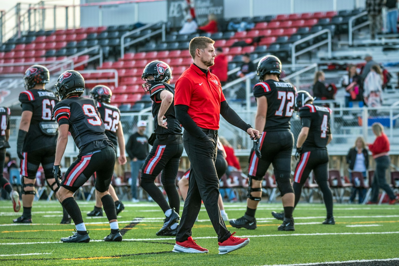 Football coach walking with players for sideline content updates